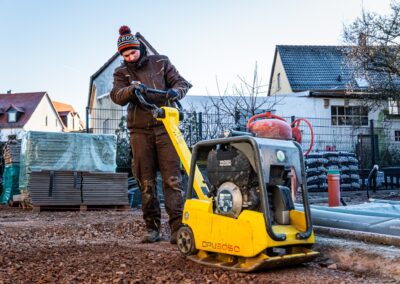 Mitarbeiter von Hund Garten- und Landschaftsbau führt im Garten eine Bodenbearbeitung durch